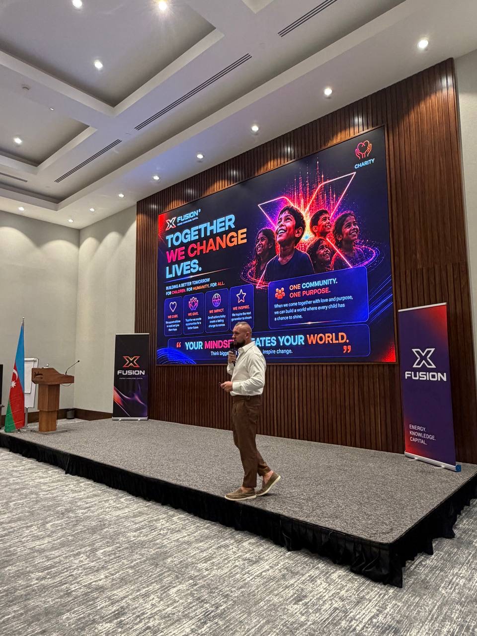 Stanis Zichler speaking on stage at an XFusion charity event in Baku, Azerbaijan